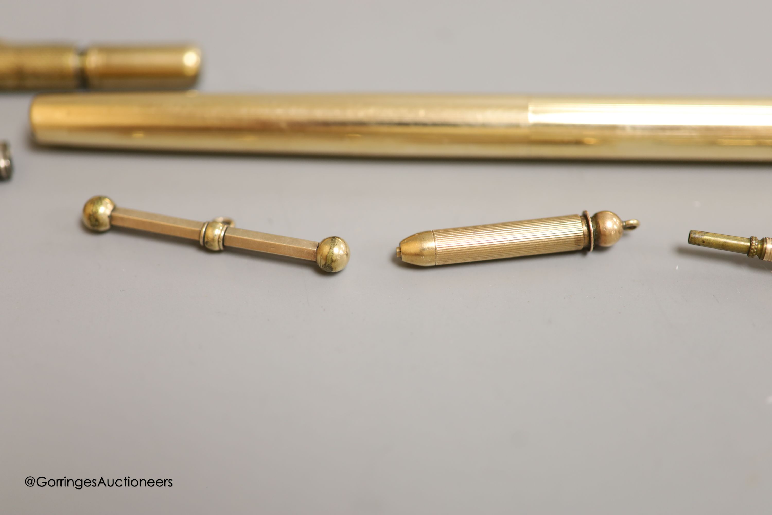 Rolled gold pens and pencils including a T-bar and two silver cased pencils.